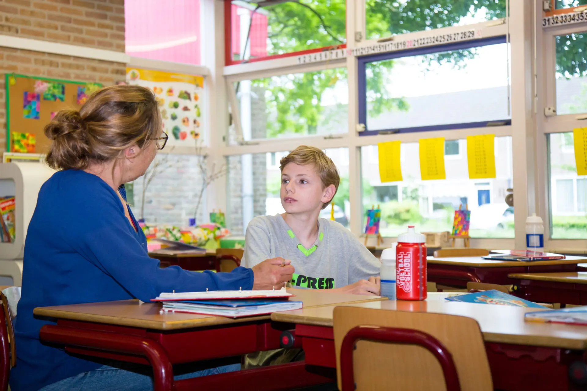 Een anti-pestbeleid belangrijk Een gesprek voeren met een jongen in een klaslokaal om het pestenprobleem aan te pakken. School en Veiligheid
