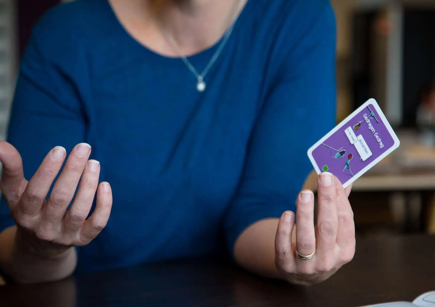 Een vrouw houdt een paarse kaart vast en lijnt haar hand ter ondersteuning van scholen bij sociale veiligheid School en Veiligheid