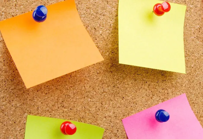 Kleurrijke sticky notes op een kurkbord vormen een actueel en levendig geheel. School en Veiligheid