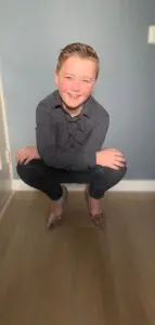 Een jongen hurkt voor een muur en zingt zachtjes 'ik ben' voor zichzelf. School en Veiligheid