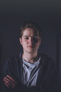 Een man in een zwart jasje, die scholen ondersteunt met sociale veiligheid. School en Veiligheid