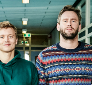 Twee mannen staan in een gang te praten over Pesten op het mbo. School en Veiligheid