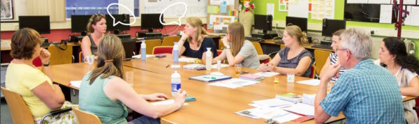 Een groep mensen die aan een tafel zit, actief deelneemt aan een gesprek en vragen stelt, terwijl hun discussie geanimeerd en levendig wordt. School en Veiligheid