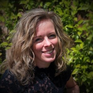 Marijke van der Zalm glimlachend voor struiken. School en Veiligheid