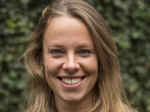 Martje Heerkens, een vrouw, glimlachend voor een heg. School en Veiligheid