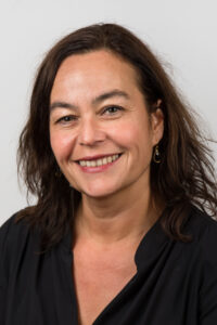Nathalie Vriezelaar, een lachende vrouw in een zwarte top. School en Veiligheid