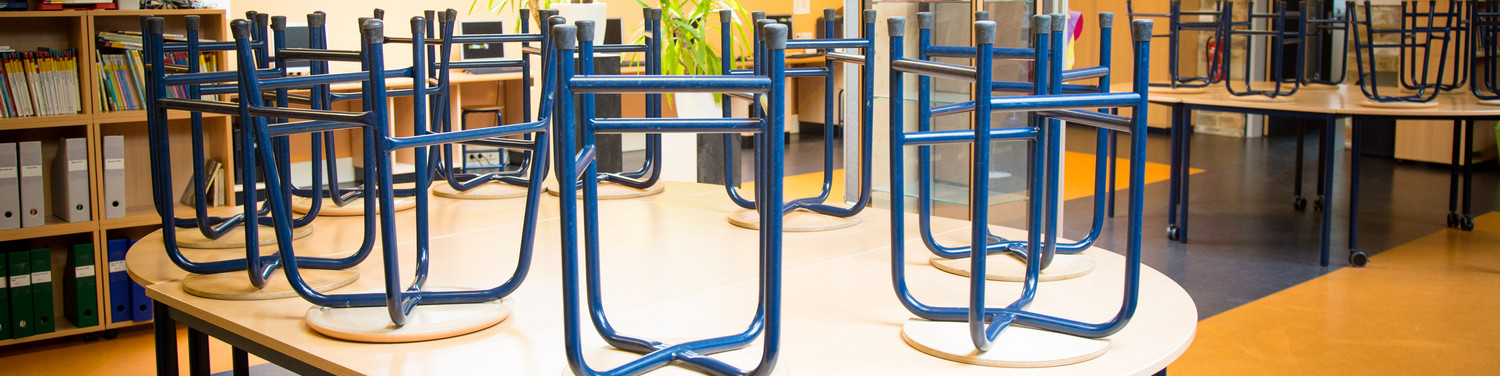 Een groep blauwe stoelen in een school. School en Veiligheid