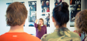 Een groep mensen die voor een muur met foto's discussiëren. School en Veiligheid