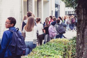 Een radicalsering in het mbo, een rij leerlingen die wacht tot ze weer naar school kunnen. School en Veiligheid