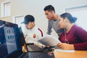 Een groep mensen die in een klaslokaal op een laptop werken en discriminatie in het mbo aanpakken. School en Veiligheid