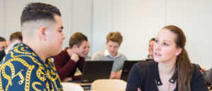 Een groep mensen zit aan een bureau in een vertrouwenswerk in het voortgezet onderwijslokaal. School en Veiligheid