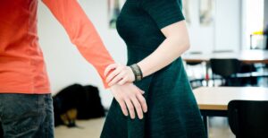 Een man houdt de hand van een vrouw vast in een intiem gebaar. School en Veiligheid