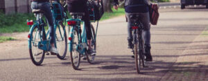 Een groep mensen die over een weg fietsen en het plezier en de kameraadschap van recreatief fietsen laten zien. School en Veiligheid