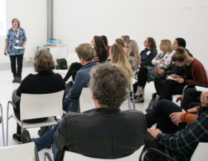 Een vrouw die een presentatie over de agenda geeft aan een groep mensen. School en Veiligheid