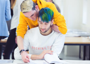 Twee mannen zitten aan een bureau met een notitieboekje en bespreken seksuele diversiteit in het voortgezet onderwijs. School en Veiligheid