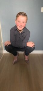 Een jongen hurkt voor een muur en zingt zachtjes 'ik ben' voor zichzelf. School en Veiligheid
