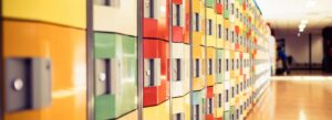 Levendige kluisjes in een gang met posters van Werken aan seksueel integer gedrag van schoolmedewerkers. School en Veiligheid