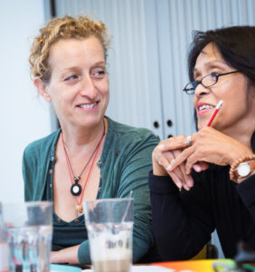 Twee vrouwen zitten aan tafel en ondersteunen scholen bij het waarborgen van de sociale veiligheid. School en Veiligheid