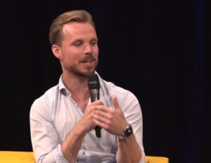 Een man spreekt in een microfoon op een Onderwijsconferentie. School en Veiligheid