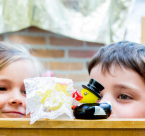 twee kinderen kijken naar verliefde speelgoedeentjes